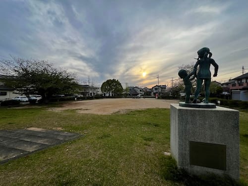 寺戸公園の記念碑「完」後方から彫像と公園広場